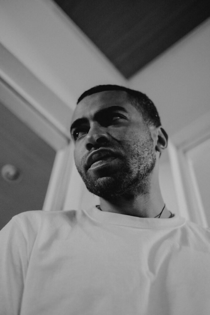 Thoughtful black and white portrait of a man in a contemplative mood indoors.