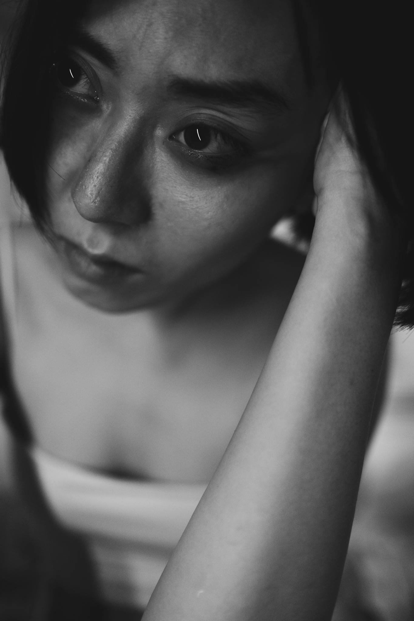 Black and white portrait of a woman expressing deep emotion and introspection.